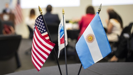 Miniature flags of Chevron, United States and Argentina on a table.