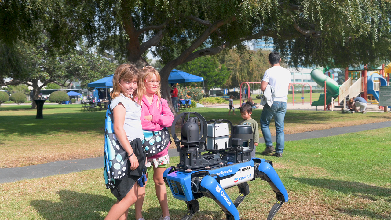 kids observing a robot dog at the El Segundo refinery tour day