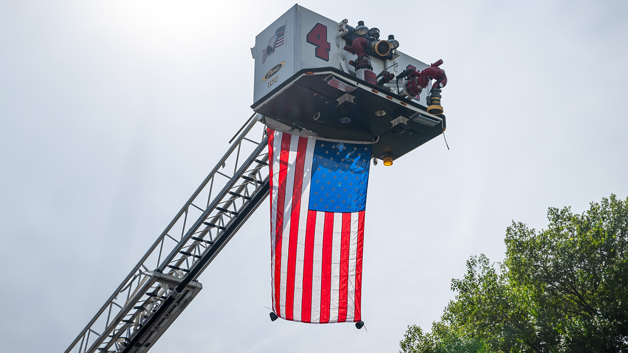 U.S. flag hanging from a fire truck ladder